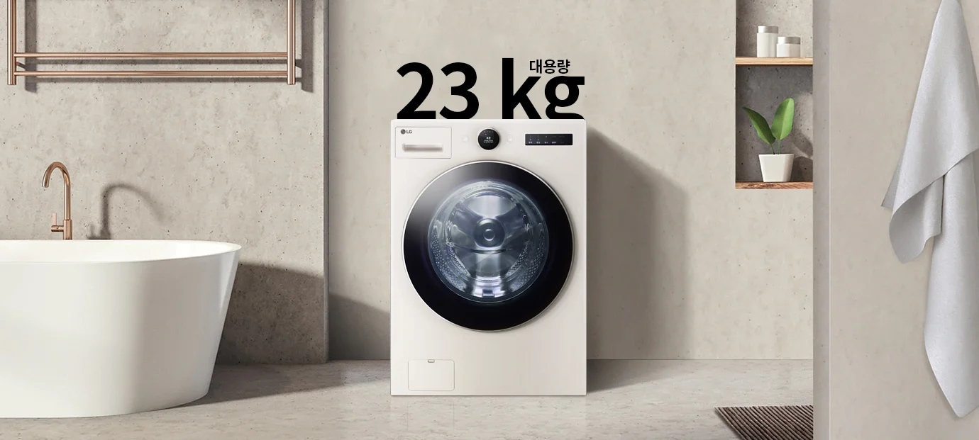 세탁기가 욕실에 놓여 있으며, 세탁기 위에는 "대용량 23 kg"이라는 문구가 있습니다. 욕조와 수건이 걸려 있고, 벽면 선반에는 화분과 용기가 놓여 있습니다.